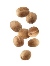 Image of Aromatic nutmeg seeds falling on white background