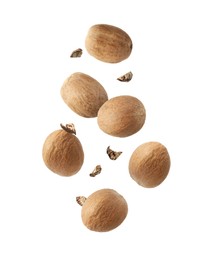 Image of Aromatic nutmeg seeds and pieces falling on white background