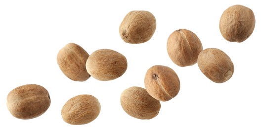 Image of Aromatic nutmeg seeds falling on white background