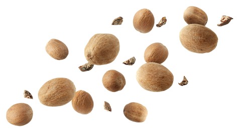 Image of Aromatic nutmeg seeds and pieces falling on white background