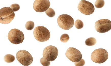 Image of Aromatic nutmeg seeds falling on white background