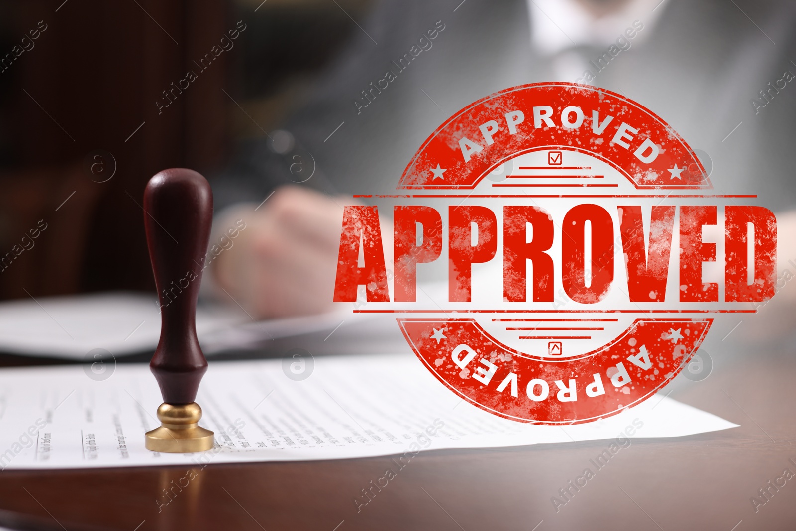 Man working with document at table and red stamp Approved Image of Man working with document at table and red stamp Approved