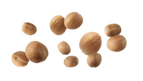 Image of Aromatic nutmeg seeds falling on white background