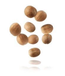 Image of Aromatic nutmeg seeds falling on white background