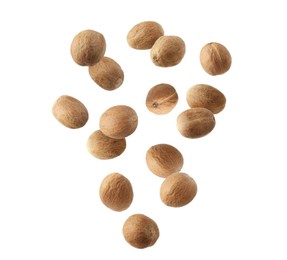 Image of Aromatic nutmeg seeds falling on white background