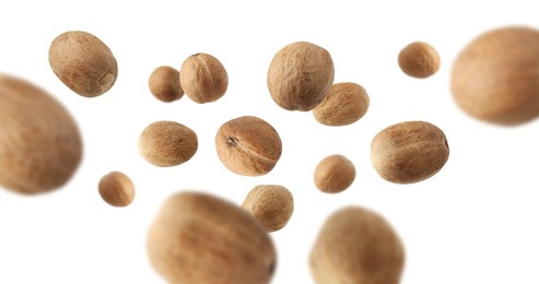 Image of Aromatic nutmeg seeds falling on white background