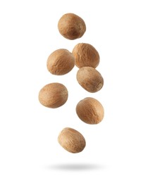 Image of Aromatic nutmeg seeds falling on white background