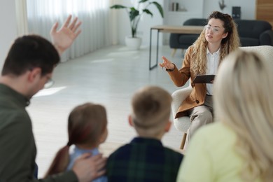 Photo of Family having consultation with psychologist in office, selective focus