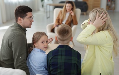 Photo of Family having consultation with psychologist in office, selective focus