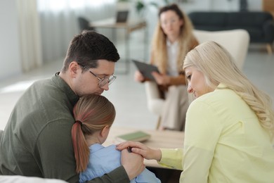 Photo of Family having consultation with psychologist in office, selective focus