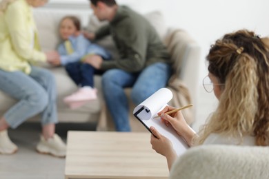 Photo of Family having consultation with psychologist in office, selective focus
