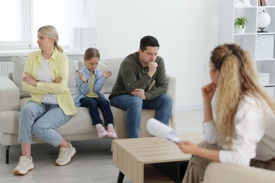 Photo of Family having consultation with psychologist in office, selective focus