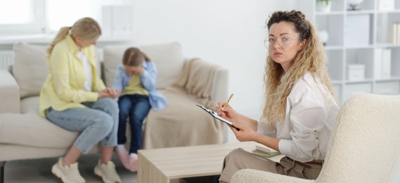 Photo of Mother and daughter having consultation with psychologist in office, selective focus