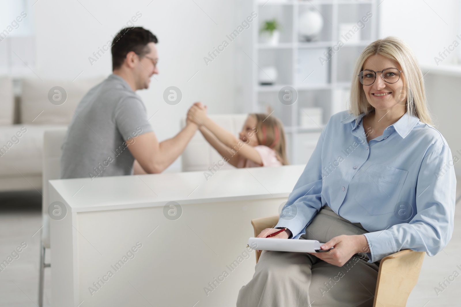 Father and daughter having consultation with smiling psychologist in office, selective focus Photo of Father and daughter having consultation with smiling psychologist in office, selective focus
