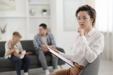 Photo of Father and son having consultation with psychologist in office, selective focus