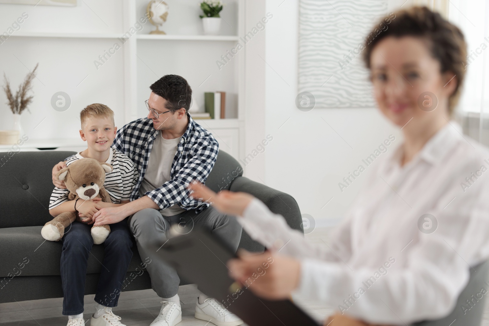 Happy father and son having consultation with psychologist in office, selective focus Photo of Happy father and son having consultation with psychologist in office, selective focus