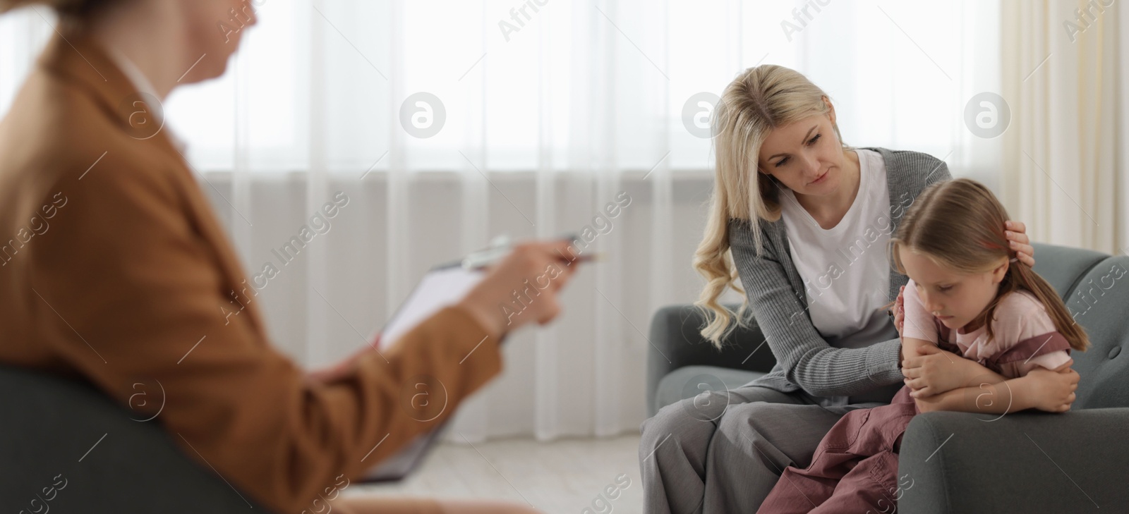 Mother and daughter having consultation with psychologist in office, selective focus Photo of Mother and daughter having consultation with psychologist in office, selective focus