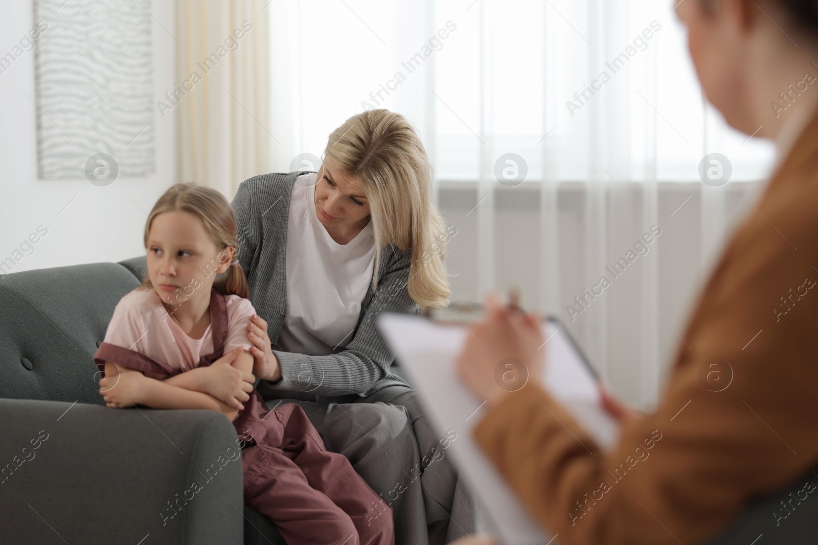 Mother and daughter having consultation with psychologist in office, selective focus Photo of Mother and daughter having consultation with psychologist in office, selective focus