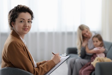 Photo of Mother and daughter having consultation with smiling psychologist in office, selective focus