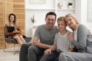 Photo of Happy family after consultation with psychologist in office, selective focus