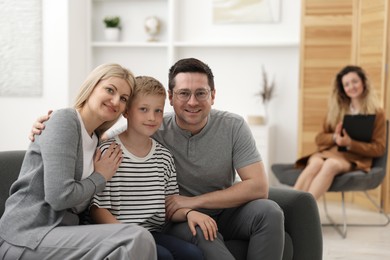 Photo of Happy family after consultation with psychologist in office, selective focus