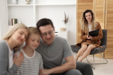 Photo of Cute family after consultation with psychologist in office, selective focus