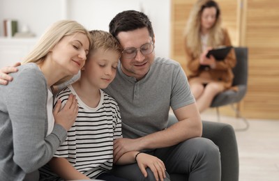 Photo of Cute family after consultation with psychologist in office, selective focus