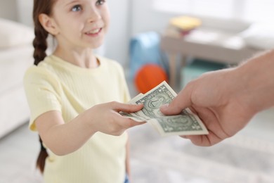 Photo of Father giving his daughter pocket money at home, closeup