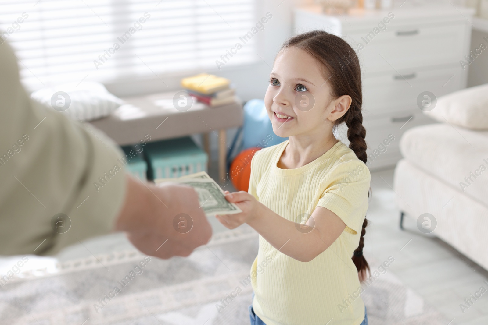 Father giving his daughter pocket money at home, closeup Photo of Father giving his daughter pocket money at home, closeup