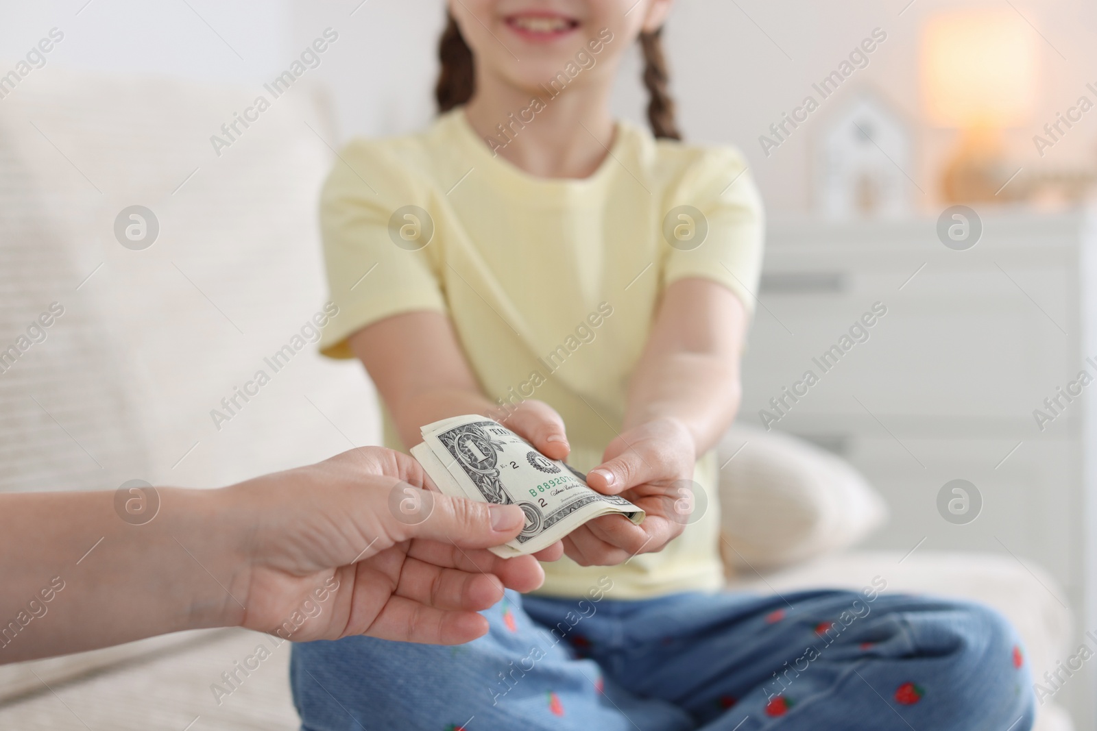 Mother giving her daughter pocket money on sofa at home, closeup Photo of Mother giving her daughter pocket money on sofa at home, closeup
