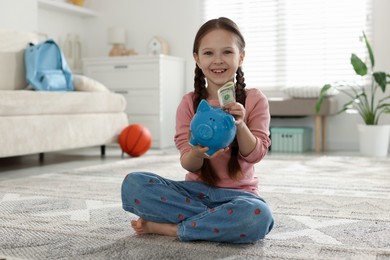 Photo of Girl with piggybank of pocket money at home