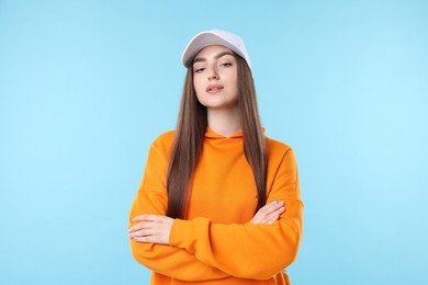 Photo of Portrait of beautiful woman in stylish baseball hat on light blue background