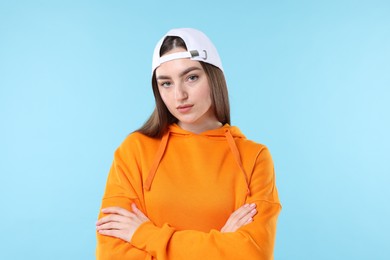 Photo of Portrait of beautiful woman in stylish baseball hat on light blue background
