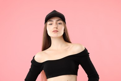 Photo of Portrait of beautiful woman in stylish baseball hat on pink background