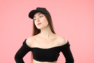 Photo of Beautiful woman in stylish baseball hat on pink background