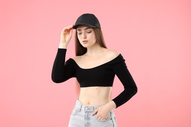 Photo of Portrait of beautiful woman in stylish baseball hat on pink background
