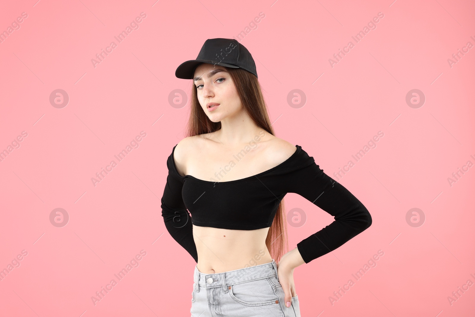 Portrait of beautiful woman in stylish baseball hat on pink background Photo of Portrait of beautiful woman in stylish baseball hat on pink background