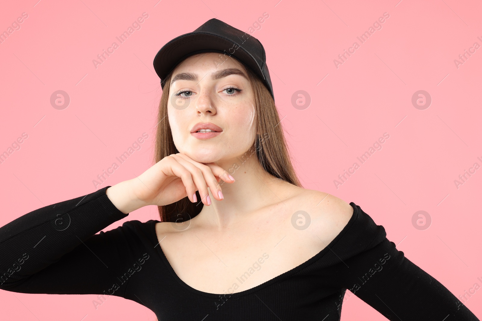 Portrait of beautiful woman in stylish baseball hat on pink background Photo of Portrait of beautiful woman in stylish baseball hat on pink background