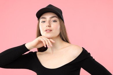 Photo of Portrait of beautiful woman in stylish baseball hat on pink background