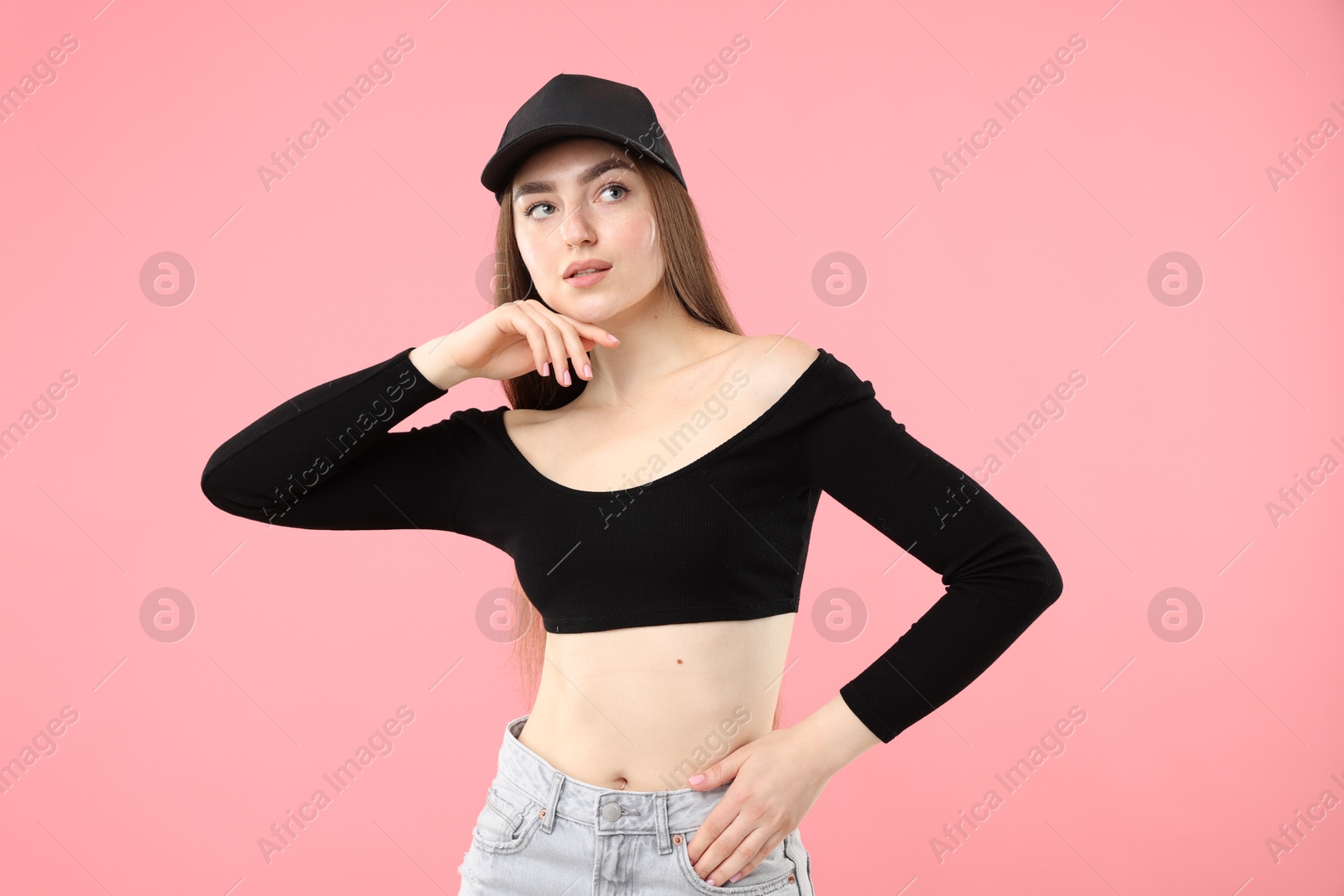 Portrait of beautiful woman in stylish baseball hat on pink background Photo of Portrait of beautiful woman in stylish baseball hat on pink background