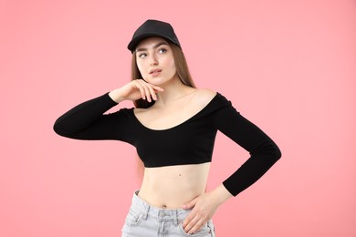 Photo of Portrait of beautiful woman in stylish baseball hat on pink background