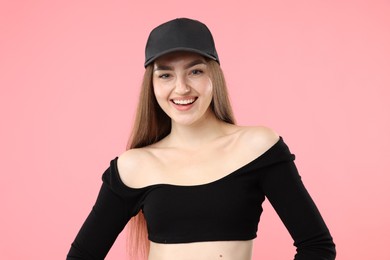 Photo of Portrait of happy woman in stylish baseball hat on pink background