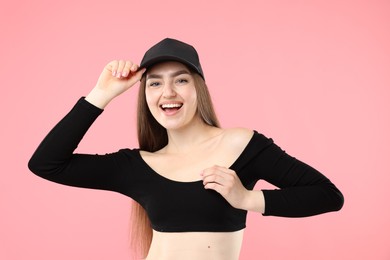 Photo of Portrait of happy woman in stylish baseball hat on pink background