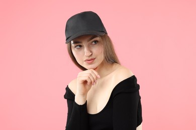 Photo of Beautiful woman in stylish baseball hat on pink background