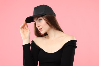 Photo of Beautiful woman in stylish baseball hat on pink background