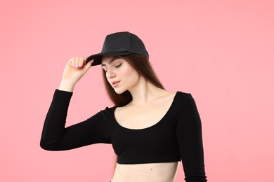 Photo of Beautiful woman in stylish baseball hat on pink background