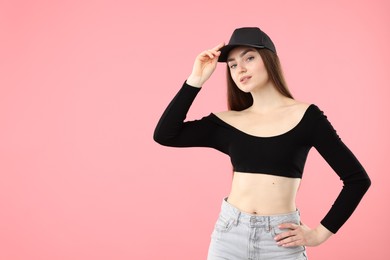 Photo of Portrait of beautiful woman in stylish baseball hat on pink background. Space for text