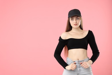 Photo of Portrait of beautiful woman in stylish baseball hat on pink background. Space for text