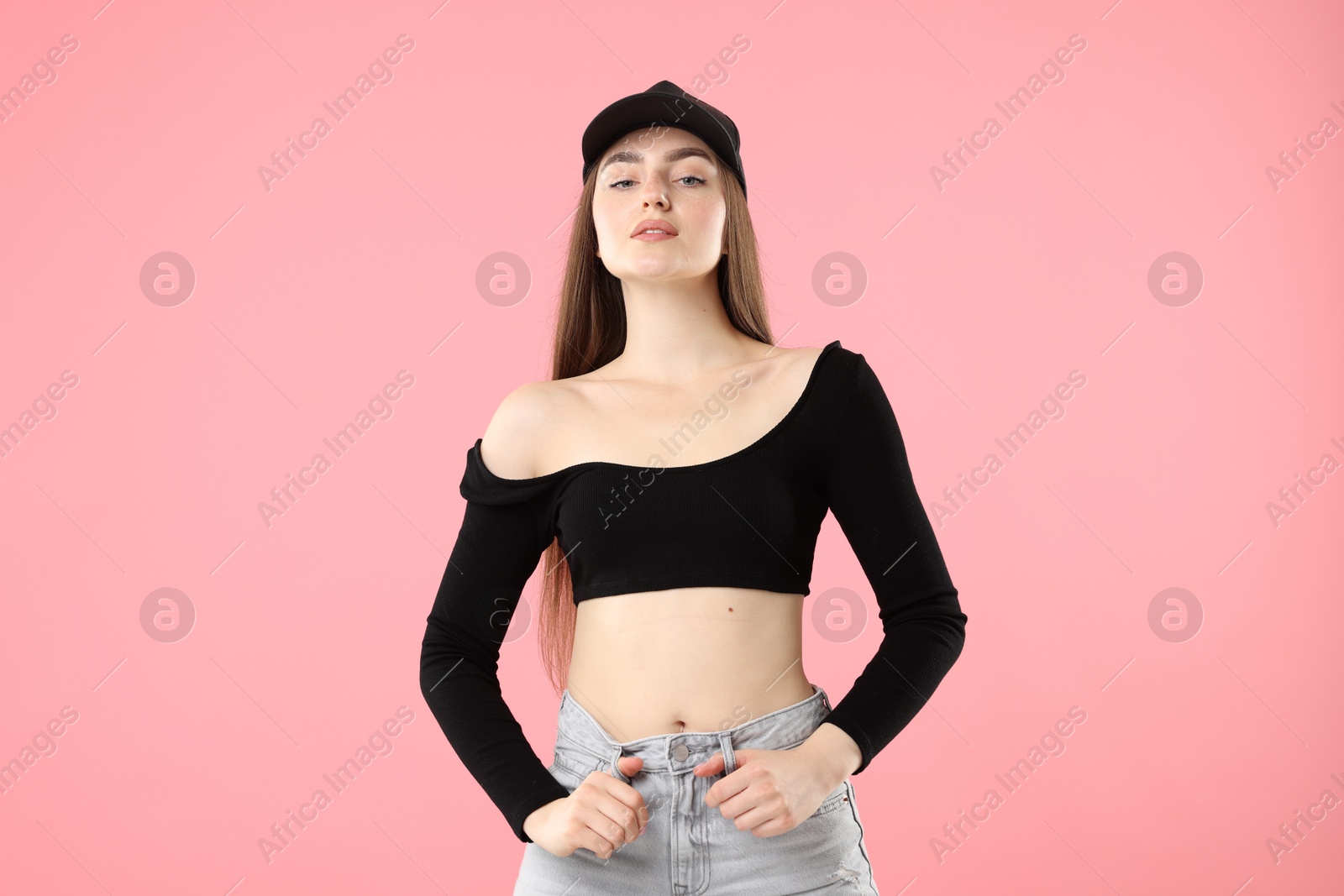 Portrait of beautiful woman in stylish baseball hat on pink background Photo of Portrait of beautiful woman in stylish baseball hat on pink background
