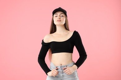 Photo of Portrait of beautiful woman in stylish baseball hat on pink background